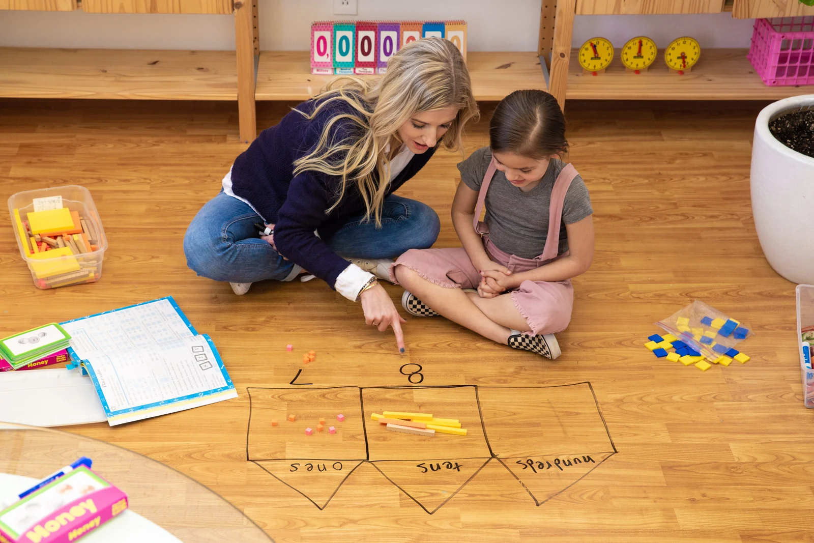 Educator using hands-on manipulatives on the floor with a student